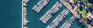 Crowded marina and blue sea with boats coming in and out on a sunny day