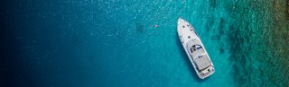 Large boat lying at anchor in blue sea 